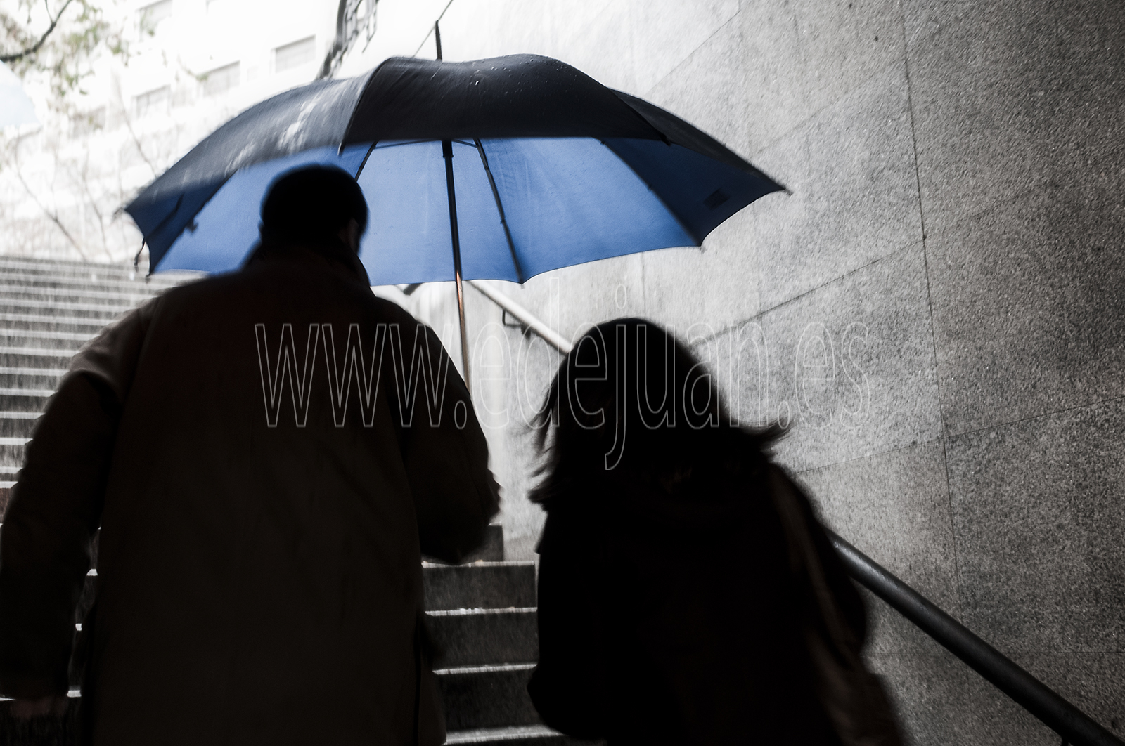 Día lluvioso, a la salida del metro de Madrid. Desaturado selectivo de la fotografía. blanco y negro más azul