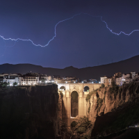 Tajo de Ronda, noche de tormenta eléctrica con relámpagos, vista de toda la cornisa incluyendo el puente del Tajo de Ronda con rayos. Fotografía realizada al anochecer con relámpagos.
